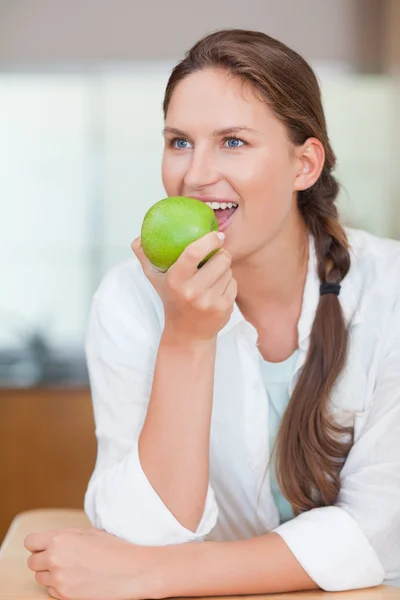 Portret van een leuke vrouw eten van een appel — Stockfoto