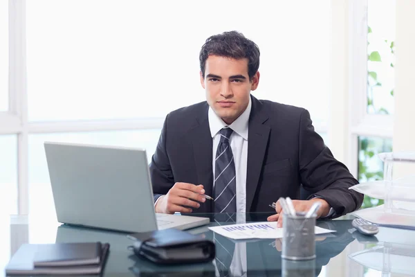 Affärsman som arbetar med en laptop och en graf — Stockfoto