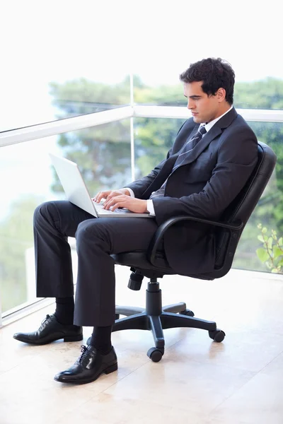 Portrait of a businessman sitting on an armchair working with a — Stock Photo, Image