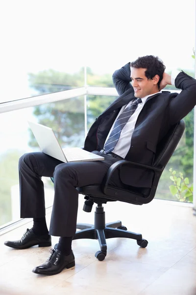 Portret biznesmena zrelaksowany siedzi na fotel pracy — Zdjęcie stockowe