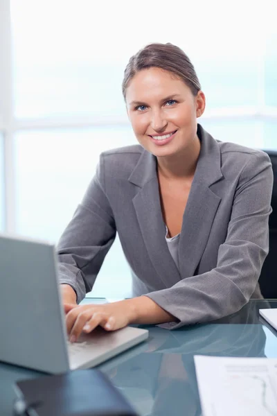 Портрет улыбающейся деловой женщины, работающей с ноутбуком — стоковое фото