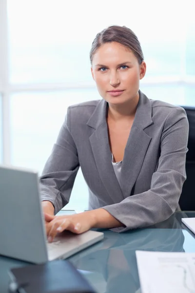 Retrato de una mujer de negocios seria que trabaja con un portátil — Foto de Stock