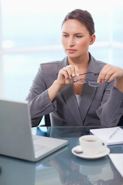 Retrato de uma mulher de negócios colocando seus óculos — Fotografia de Stock