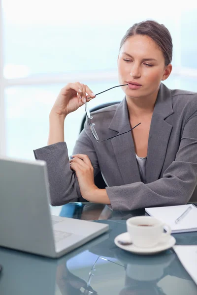 Retrato de una mujer de negocios reflexiva usando una computadora portátil — Foto de Stock