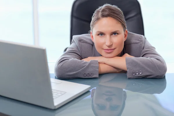 Mujer de negocios apoyada en su escritorio — Foto de Stock