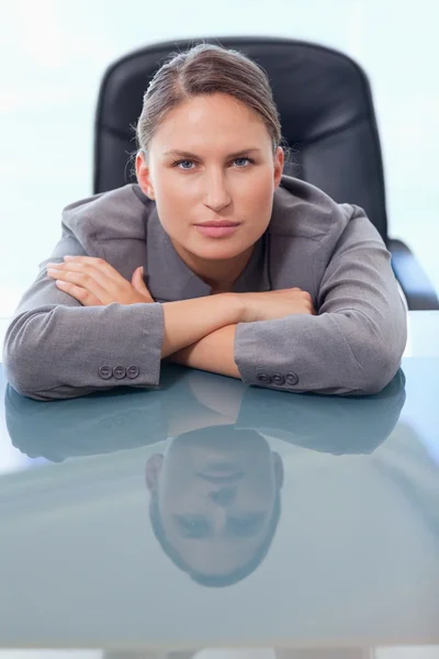 Portret młodego interesu, opierając się na jej biurku — Zdjęcie stockowe