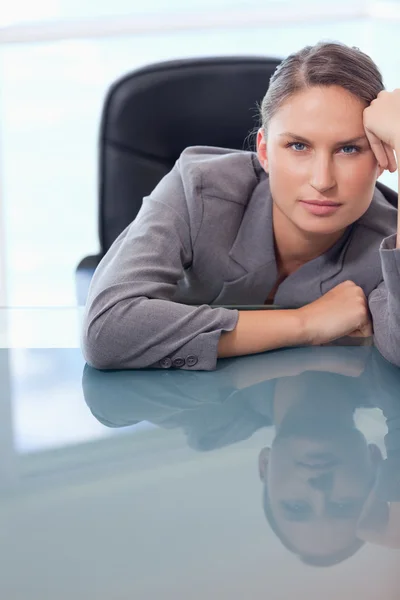 Portrait of a bored businesswoman leaning on her desk — Stock Photo, Image