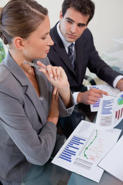 Porträtt av en seriös ung verksamhet team studerar statistik — Stockfoto