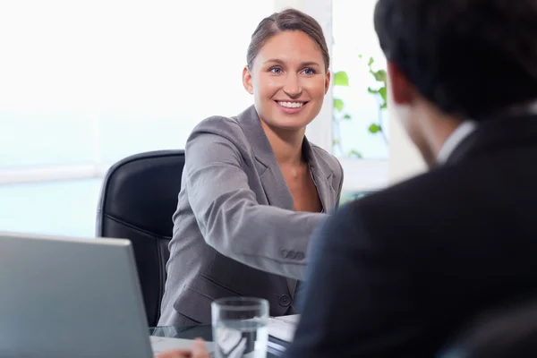 Glimlachende zakenvrouw verwelkomt klant — Stockfoto