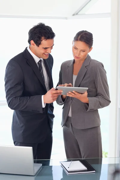 Geschäftspartner schauen gemeinsam auf Tablet — Stockfoto