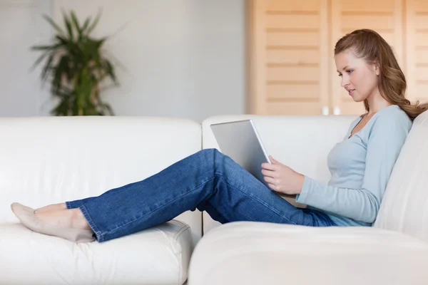 Woman working on her notebook on the sofa — Stock Photo, Image