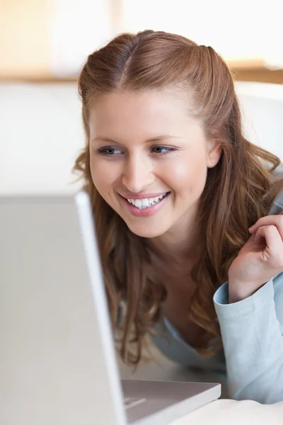 Primo piano di femmina sorridente utilizzando il suo computer portatile — Foto Stock