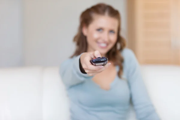 Remote being used by young woman — Stock Photo, Image