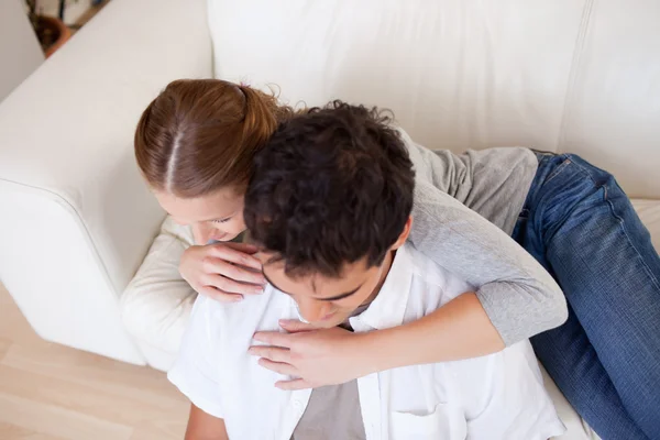 Жінка обіймає свого хлопця на дивані — стокове фото