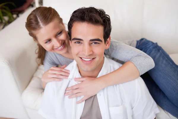 Muž se objal svou přítelkyni na pohovce — Stock fotografie