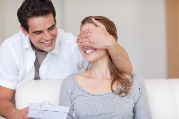 Man surprising his girlfriend with a present — Stock Photo, Image
