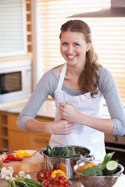Vrouw peper toe te voegen aan haar maaltijd — Stockfoto