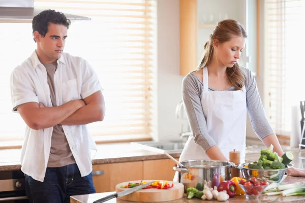 Man watches his girlfriend cooking — Stock Photo, Image