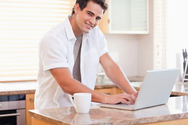 Male working on his laptop in the kitchen — Stock Photo, Image