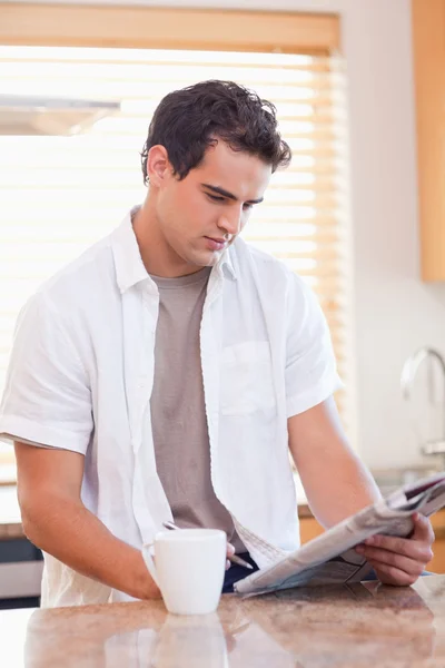 Man doing crossword puzzle in the kitchen — Stock Photo, Image