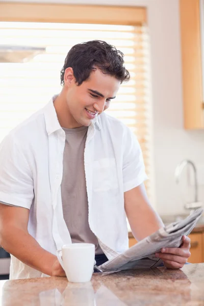 Man reading newspaper in the kitchen — Stock Photo, Image