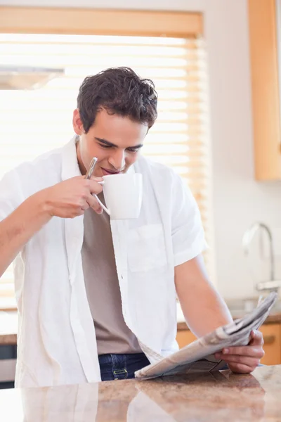 Man having some coffee while reading the newspaper — Zdjęcie stockowe