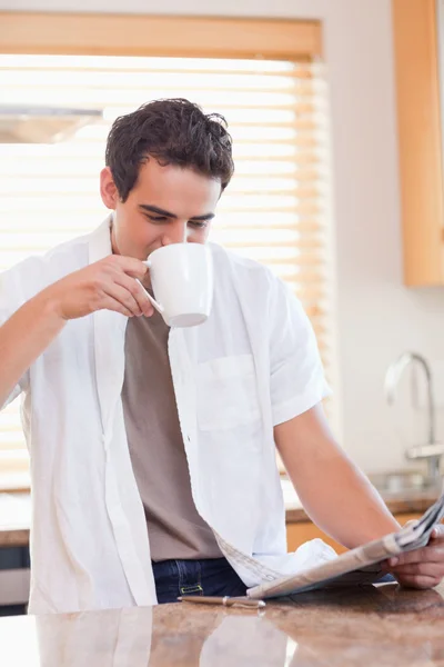Άνθρωπος, πίνοντας έναν καφέ διαβάζοντας την εφημερίδα — Φωτογραφία Αρχείου