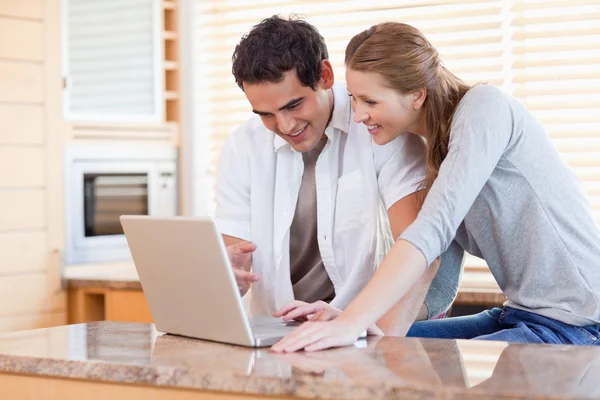 Couple surfing the internet in the kitchen — Stock Photo, Image