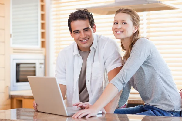Couple with notebook in the kitchen — Stock Photo, Image