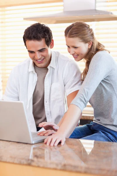 Couple surfing the web in the kitchen — Stock Photo, Image