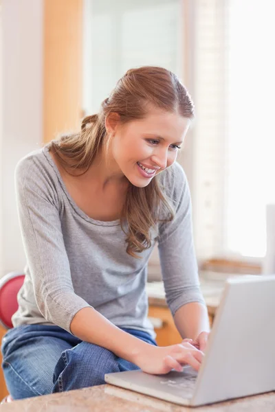 Woman surfing the internet in the kitchen — Stock Photo, Image