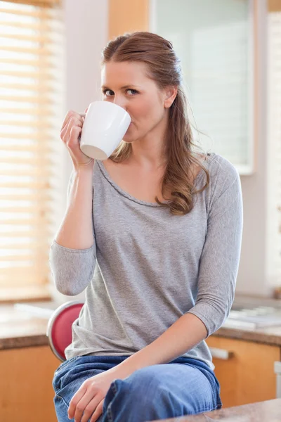 Vrouw die koffie drinkt in de keuken — Stockfoto