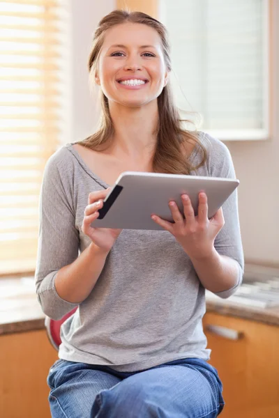 Usmívající se žena v kuchyni s tabletem — Stock fotografie