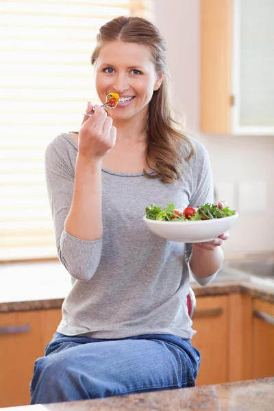 Vrouw sommige salade eten in de keuken — Stockfoto