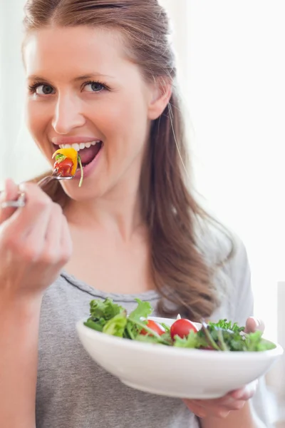 Primer plano de la mujer sonriente comiendo ensalada — Foto de Stock