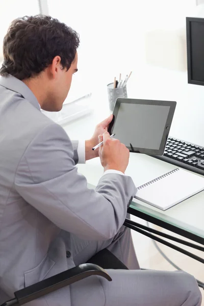 Empresário usando seu tablet em seu escritório — Fotografia de Stock