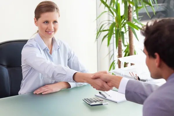 Konsultant drżenie rąk z jej klienta — Zdjęcie stockowe