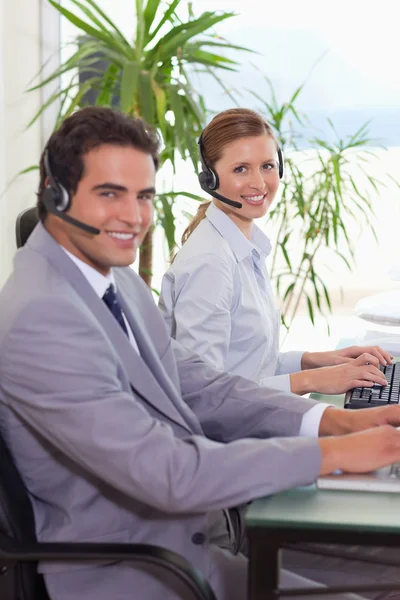 Side view of smiling call center agents — Stock Photo, Image
