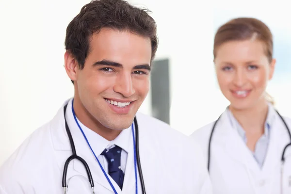 Uśmiechający się asystent lekarze stojąc obok siebie — Zdjęcie stockowe