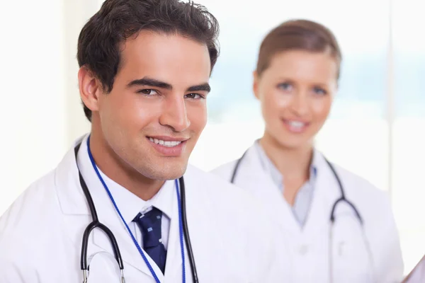Lachende medisch assistenten permanent naast elkaar — Stockfoto