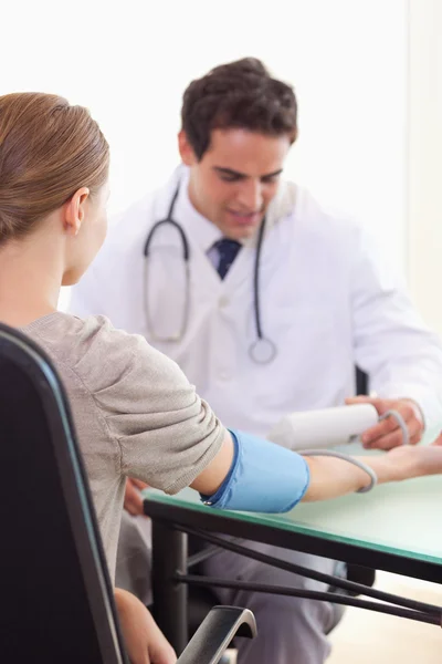 Доктор проверяет кровяное давление своих пациентов — стоковое фото