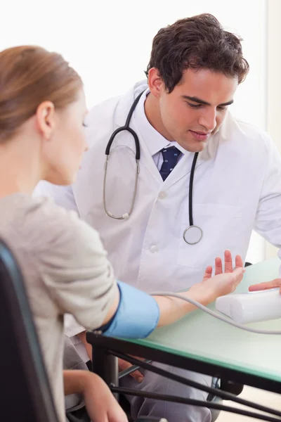 Dokter die zijn patiënten bloeddruk meet — Stockfoto