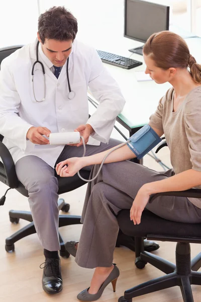 Visão lateral do médico tomando a pressão arterial de seus pacientes — Fotografia de Stock