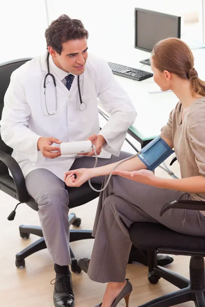 Вид сбоку врача, говорящего со своим пациентом о кровяном давлении — стоковое фото