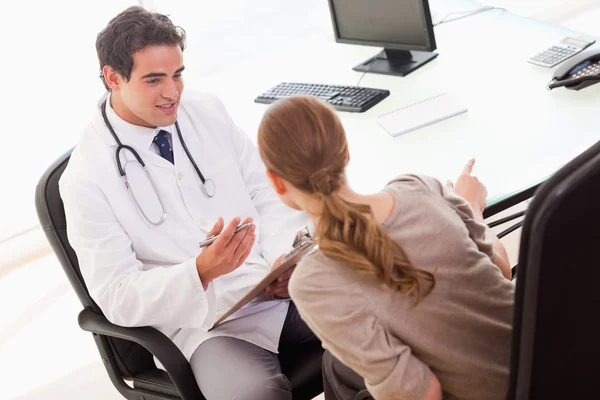 Médico preguntando a su paciente por síntomas — Foto de Stock