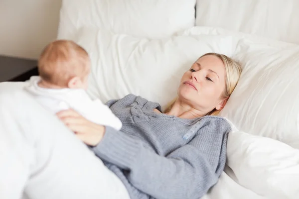 Mama leży w łóżku z jej dzieckiem — Zdjęcie stockowe