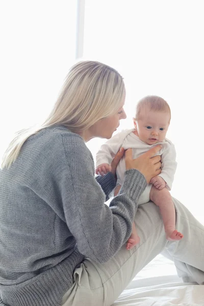 Bebeği ile dizlerinin üzerinde oturan Anne — Stok fotoğraf