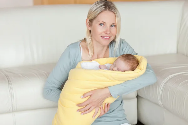 Anne kucağında bebeği ile katta oturan — Stok fotoğraf
