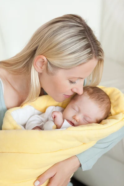 Affectionate mother kissing her sleeping baby in her arms — Stock Photo, Image