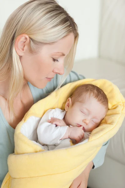 Madre mirando a su lindo bebé en sus brazos — Foto de Stock